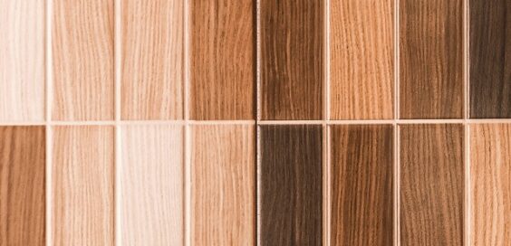 Two rows of rectangular wooden floor tiles are displayed in a gradient from light to dark brown tones.