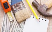 An overhead view shows money, a calculator, a notebook, and tools to plan and budget for home remodeling.