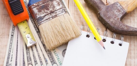 An overhead view shows money, a calculator, a notebook, and tools to plan and budget for home remodeling.
