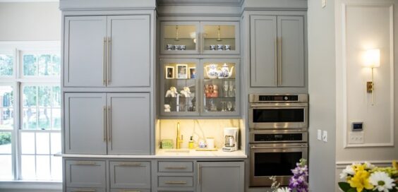 Grey modern kitchen cabinets in a large, expensive kitchen in a newly built modern, luxury home with built-in appliances.