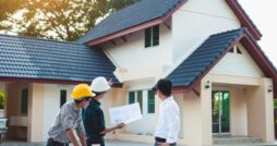 A homeowner talks with two contractors about the exterior details of a renovation project on his home.