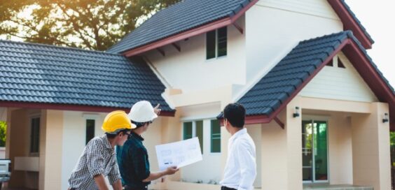 A homeowner talks with two contractors about the exterior details of a renovation project on his home.
