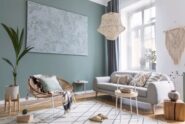Modern living room with neutral furniture, woven pendant light, abstract wall art, and abundant natural light.