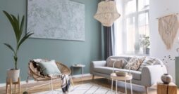 Modern living room with neutral furniture, woven pendant light, abstract wall art, and abundant natural light.
